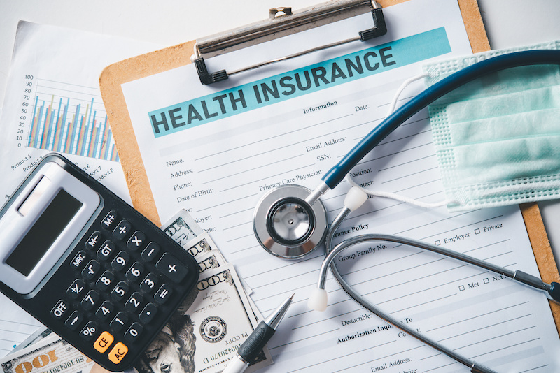 Stethoscope and calculator placed on health insurance documents