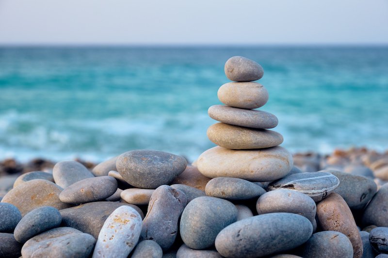 Balanced zen stones stacked close up on a beautiful beach
