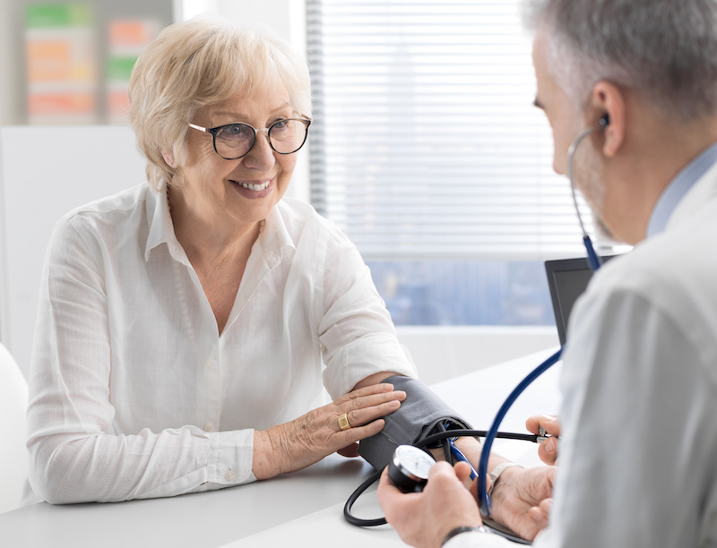 Doctor visiting a senior patient and measuring blood pressure